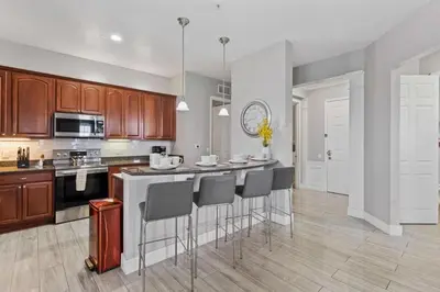 a kitchen with a island with bar stools at Amplo Apartamento 4 Quartos no Vista Cay Resort in Orlando