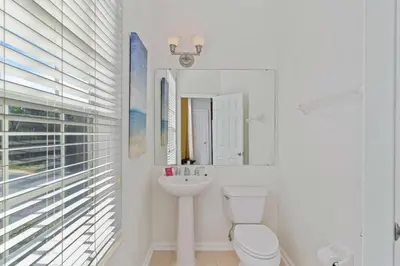 a white bathroom with a toilet and a sink at Apartamento 3 Quartos no Vista Cay Resort in Orlando