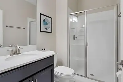 a white bathroom with a toilet and a shower at Casa Familiar 10min da Disney + Piscina Privativa in Kissimmee