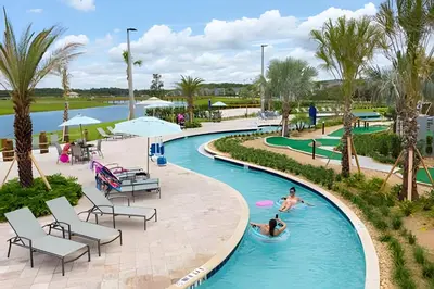 a pool at a resort with people swimming in it at Casa Familiar 10min da Disney + Piscina Privativa in Kissimmee