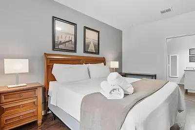 a bedroom with a large white bed with towels on it at Casa 3Q Moderna c/ Piscina e Clube Resort in Kissimmee