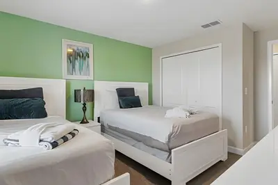 two beds in a bedroom with green walls at Casa 4Q Moderna c/ Lazy River e Toboáguas in Kissimmee