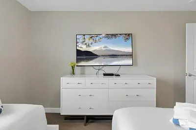 a living room with a tv on a white dresser at Casa 4Q Moderna c/ Lazy River e Toboáguas in Kissimmee