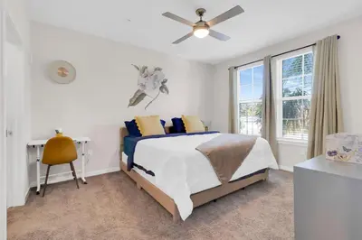 a bedroom with a bed and a desk and a window at Modern 2 Bedrm Apartment with fast Wi-fi - Apartment in Orlando