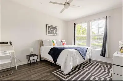 a white bedroom with a bed and a window at LuXury Stay | Pool + Gym + Fast Wi-fi in Orlando