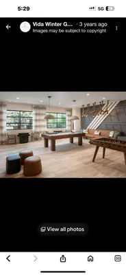 a view of a living room with a table and benches at LuXury Stay | Pool + Gym + Fast Wi-fi in Orlando
