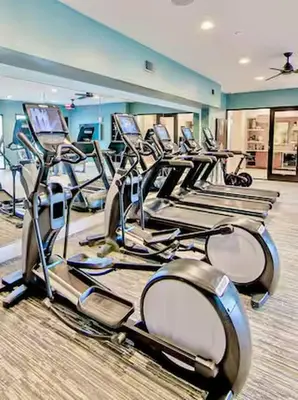 a gym with rows of cardio bikes and treadmills at LuXury Stay | Pool + Gym + Fast Wi-fi in Orlando