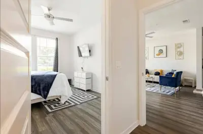a white bedroom with a bed and a living room at LuXury Stay | Pool + Gym + Fast Wi-fi in Orlando