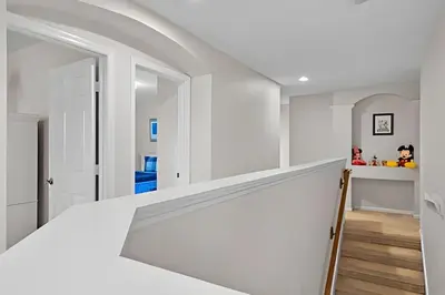 a staircase in a house with white walls and wood floors at Casa 5Q Piscina Resort Windsor Hills Disney in Orlando