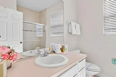 a white bathroom with a sink and a toilet at Casa 5Q Piscina Resort Windsor Hills Disney in Orlando