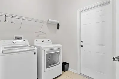 a white kitchen with a stove and a dishwasher at Casa 5Q Piscina Resort Windsor Hills Disney in Orlando