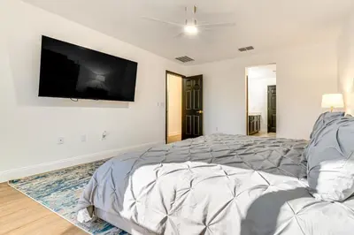 a bedroom with a large bed and a flat screen tv at Modern Resort Getaway 9 Mi to Disney Parks! in Kissimmee