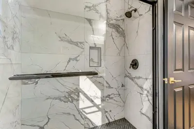 a shower with marble walls and a glass door at Modern Resort Getaway 9 Mi to Disney Parks! in Kissimmee