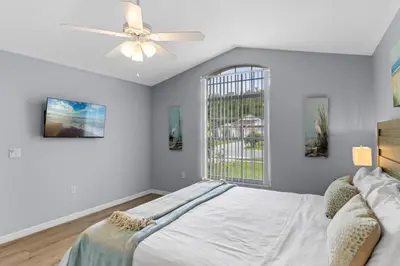 a bedroom with a bed and a ceiling fan at Orlando Family Retreat 4BR, Private Pool and Lake in Kissimmee