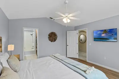 a white bedroom with a bed and a ceiling fan at Orlando Family Retreat 4BR, Private Pool and Lake in Kissimmee