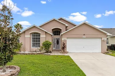 a house with a white garage at Orlando Family Retreat 4BR, Private Pool and Lake in Kissimmee