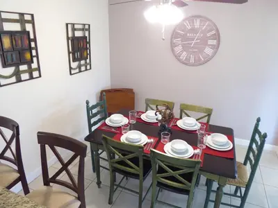 a dining room table with chairs and a clock on the wall at Perfecto Mundo 3, Orlando Area 5BR-2BA-Outdoor Pool-Jacuzzi-Billiard in Orlando