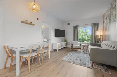 a living room with a table and chairs and a couch at Suite near Disney, free parking and shuttle to Parks in Orlando