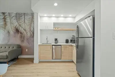 a kitchen with a stainless steel refrigerator in a room at Suite near Disney, free parking and shuttle to Parks in Orlando