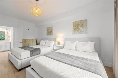 a bedroom with two beds and a chandelier at Suite near Disney, free parking and shuttle to Parks in Orlando