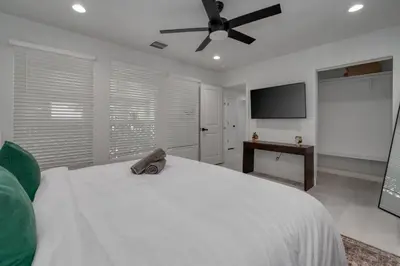 a bedroom with a white bed with a ceiling fan at Orlando Lake View Entire Home-NearDowntown in Orlando