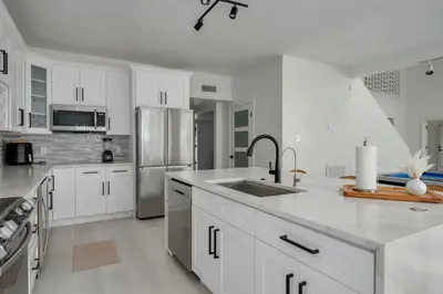a kitchen with white cabinets and a stainless steel refrigerator at Orlando Lake View Entire Home-NearDowntown in Orlando