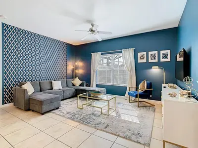 a living room with a couch and a table at Paradise Palms Disney Retreat 5BR Pool Home in Kissimmee