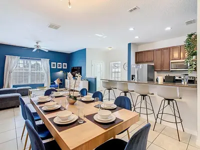 a dining room and kitchen with a table and chairs at Paradise Palms Disney Retreat 5BR Pool Home in Kissimmee