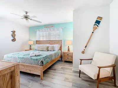 a bedroom with a bed and a chair at Paradise Palms Disney Retreat 5BR Pool Home in Kissimmee