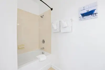 a white bathroom with a tub and a shower at Epic Universe Vacation Townhome, Vista Cay - 4035 in Orlando