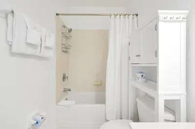 a white bathroom with a shower and a bath tub at Epic Universe Vacation Townhome, Vista Cay - 4035 in Orlando