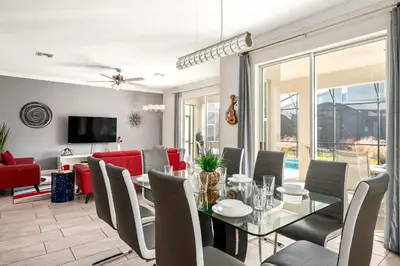 a dining room with a glass table and chairs at Heated Pool Game Room Waterpark 9MI to Disney in Kissimmee