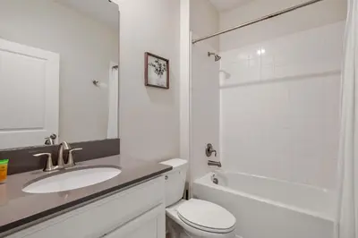 a white bathroom with a sink and a toilet at Heated Pool Game Room Waterpark 9MI to Disney in Kissimmee