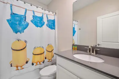 a bathroom with a sink and a toilet with a shower curtain at Heated Pool Game Room Waterpark 9MI to Disney in Kissimmee