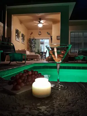 a table with a martini and a drink and a candle at Villa Coco in Kissimmee