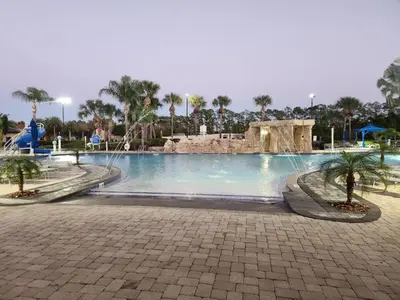 a swimming pool at a resort with palm trees at Villa Coco in Kissimmee