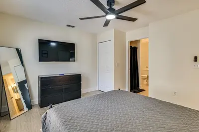 a bedroom with a bed and a flat screen tv at 10 Mi to Animal Kingdom Clermont Home with Pool! in Orlando