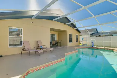 a large swimming pool with two chairs and a table at 10 Mi to Animal Kingdom Clermont Home with Pool! in Orlando