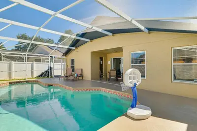 a swimming pool with a basketball hoop in a house at 10 Mi to Animal Kingdom Clermont Home with Pool! in Orlando