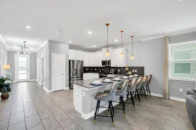 a kitchen and dining room with a table and chairs at Storey Lake Casa 9Q c Piscina, Cinema e Game Room in Kissimmee