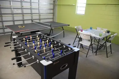 a ping pong table and two tables and chairs in a room at Perfecto Mundo 2, Orlando Area 4BR-2B-Outdoor Pool-Jacuzzi-Billiard in Orlando