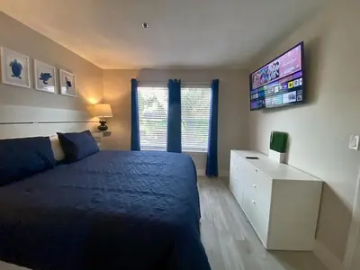 a bedroom with a bed and a tv on the wall at Sea World Orlando Apt - Minutes From Parks in Orlando