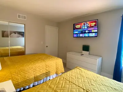 a bedroom with two beds and a tv on the wall at Sea World Orlando Apt - Minutes From Parks in Orlando