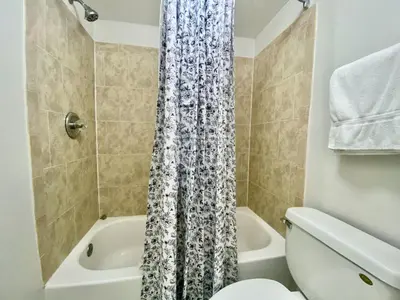 a bathroom with a toilet and a shower curtain at Sea World Orlando Apt - Minutes From Parks in Orlando
