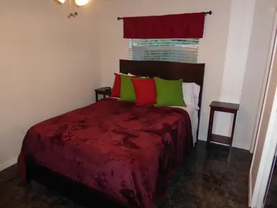 a bedroom with a bed with green and red pillows at Perfecto Mundo 4, Orlando Area 4BR-2BA Jacuzzi-Billiard-Ping Pong-City Pool in Orlando