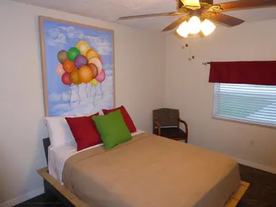 a bedroom with a bed with balloons on the wall at Perfecto Mundo 4, Orlando Area 4BR-2BA Jacuzzi-Billiard-Ping Pong-City Pool in Orlando