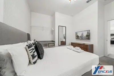 a white bedroom with a large bed with white sheets at The Epic Venice Paradiso Grande Orlando Florida in Orlando