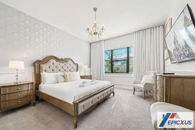a bedroom with a large bed and a chandelier at The Epic Venice Paradiso Grande Orlando Florida in Orlando