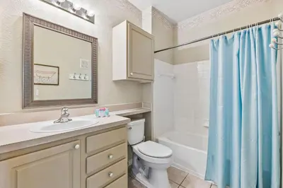a bathroom with a sink and a toilet and a tub at 8805 Dunes Court Unit 5-202 in Kissimmee