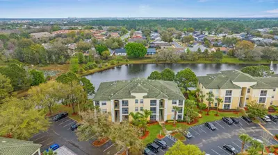 an aerial view of aominium complex with a lake at 8805 Dunes Court Unit 5-202 in Kissimmee